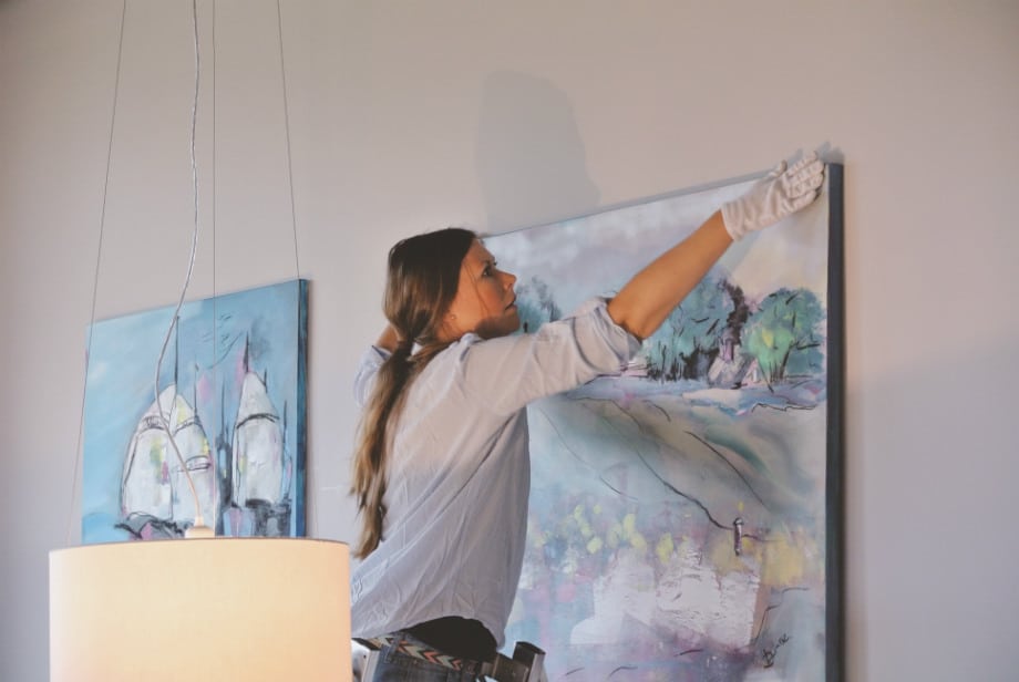 Künstlerin Diana Linsse hängt ihre Mixed Media Kunstwerke im ROBINSON Club Ampflwang an die Wand für die Ausstellung 2017